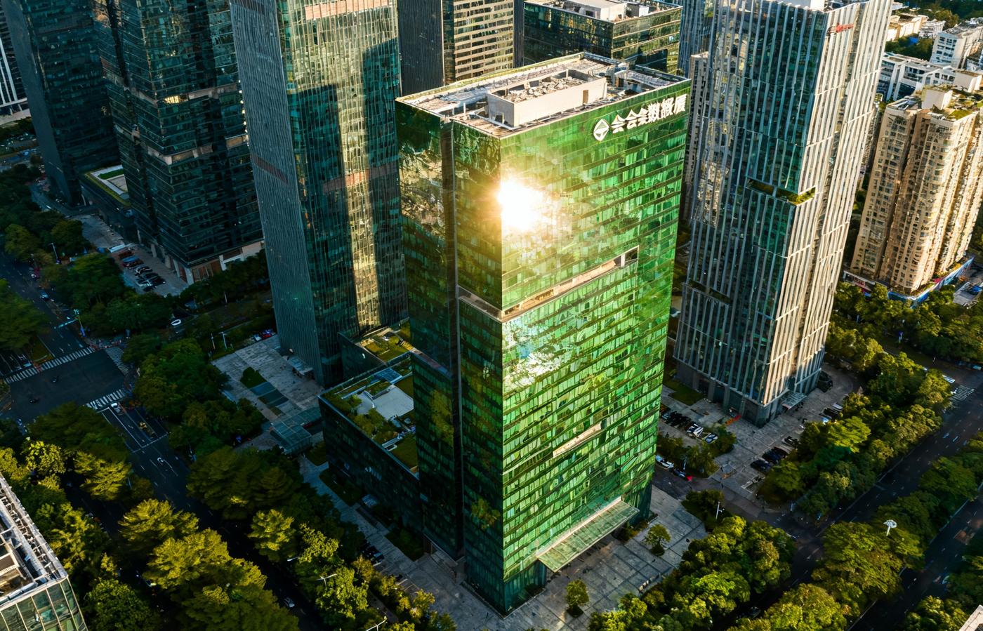深圳南山区科技园航拍全景，多栋现代化玻璃幕墙写字楼在阳光下熠熠生辉，华体会数据大厦位于画面中央偏右位置，周边绿树成荫