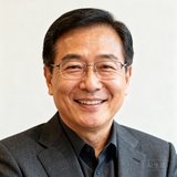 某知名体育媒体主编李伟明的头像，一位戴着眼镜的45岁男性，穿着深灰色西装，面带微笑