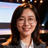 某体育数据APP创始人陈思琪的头像，一位30岁出头的女性创业者，戴着圆框眼镜，背景是产品发布会的舞台